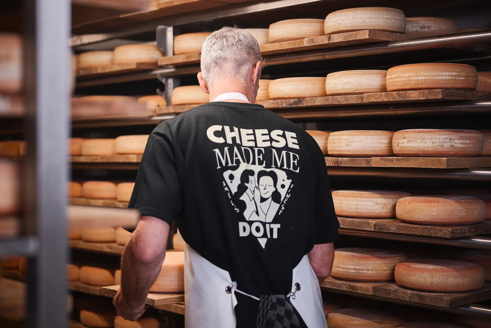 Jürgen Reinertz von hinten im Käsekeller, auf dem Rücken des T-Shirts der Druck Cheese made me do it